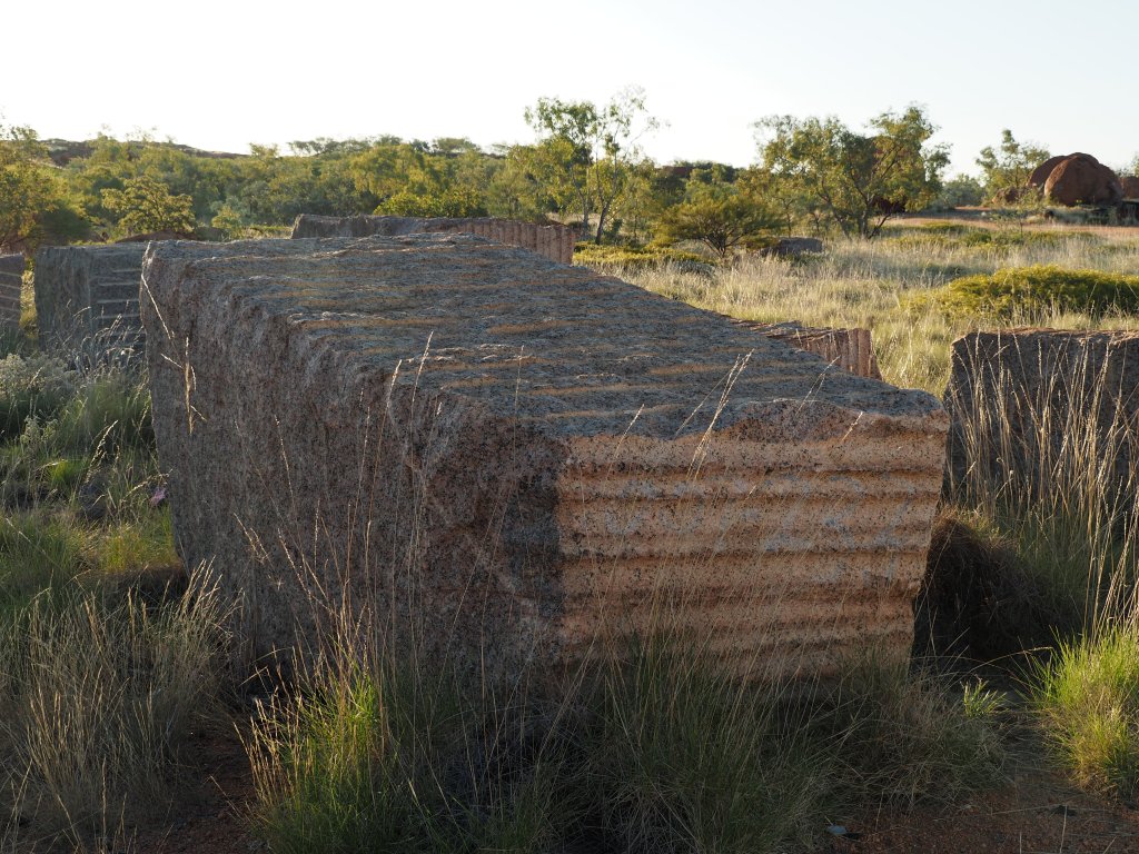 massive blocks of mined granite lie abandoned in the spinifex, near Mount Isa